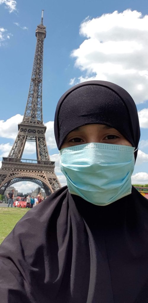 Muslimin trägt Hijab und Gesichtsmaske in Paris vor dem Eiffelturm